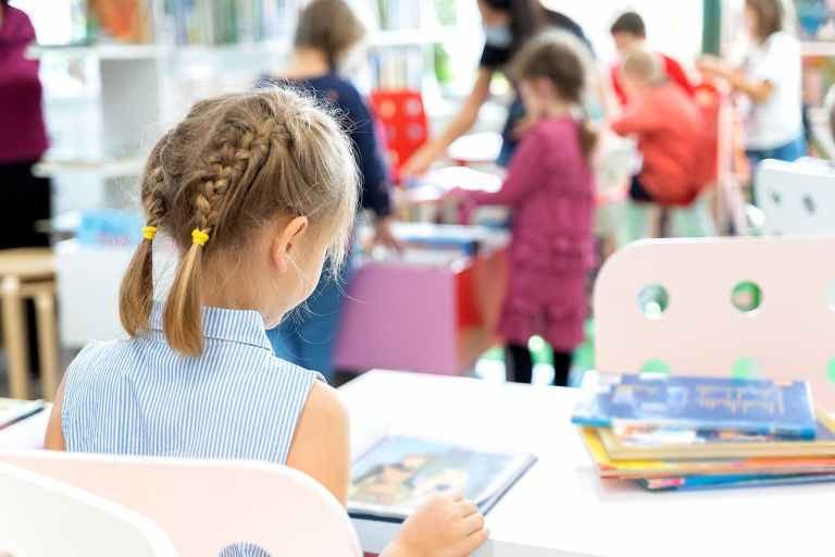 Young girl reading a book in school