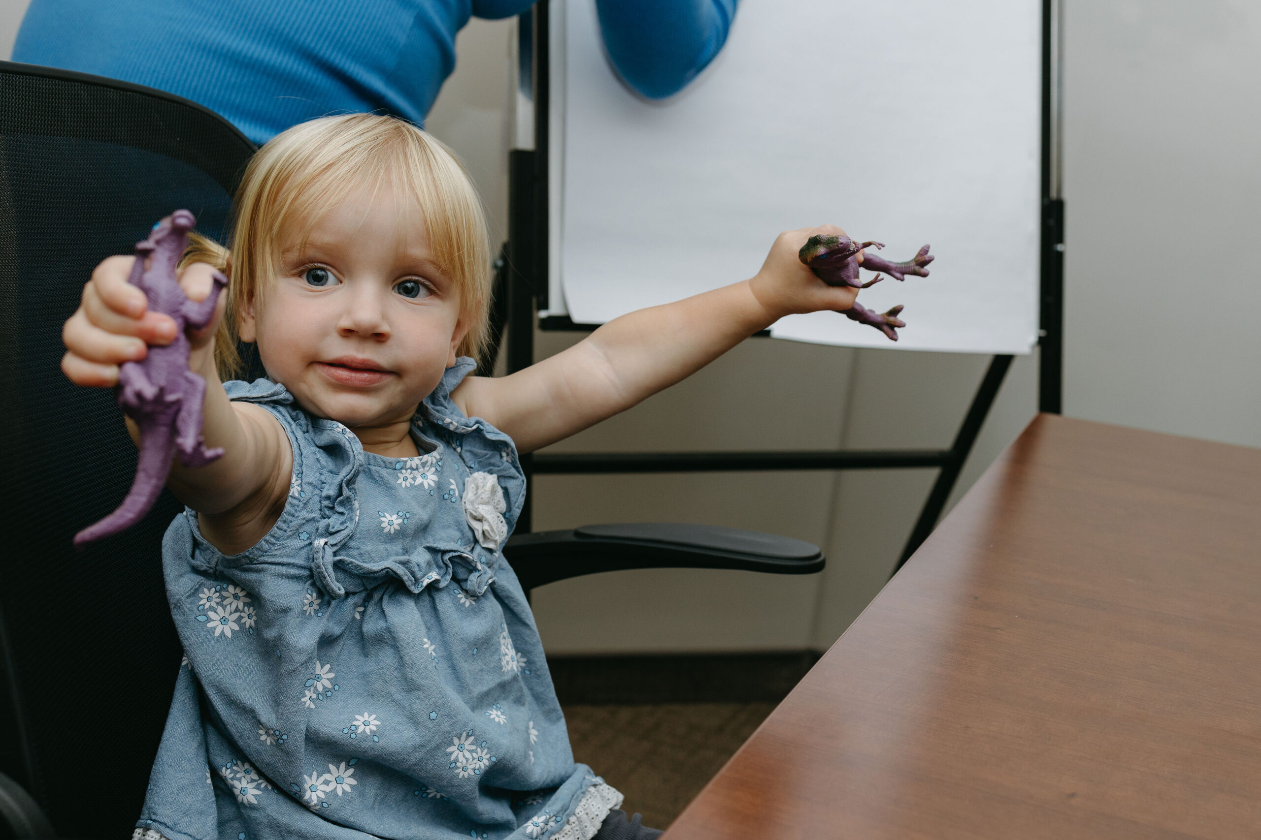 Young child playing with toy dinosaurs, representing the significance of family connections and the role of Saskatoon paternity lawyers in child-related legal matters.