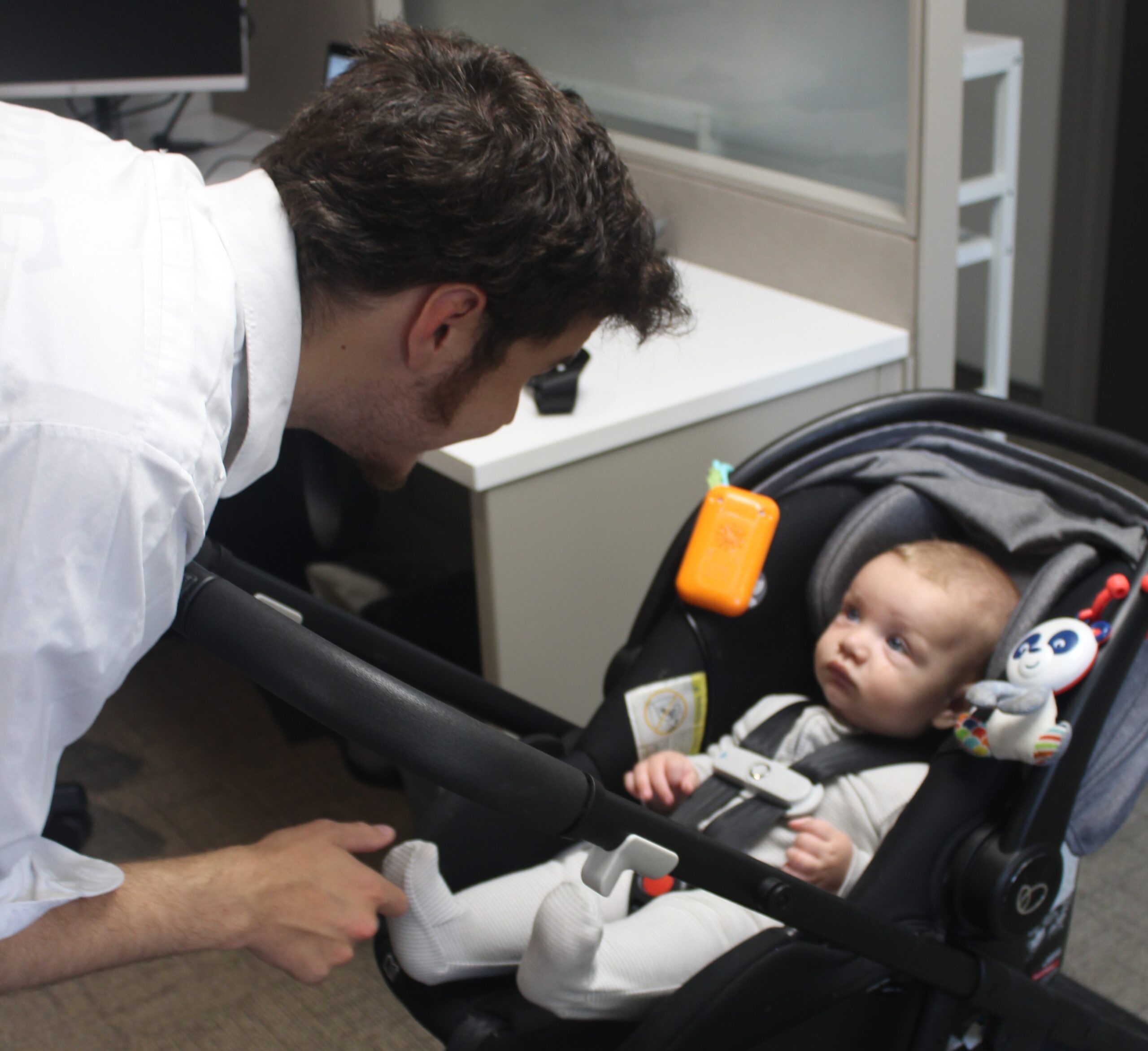 Man engaging with a baby in a stroller, illustrating outcomes of paternity establishment for child support and parental rights.