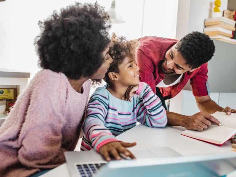 Two parents helping their child with homework