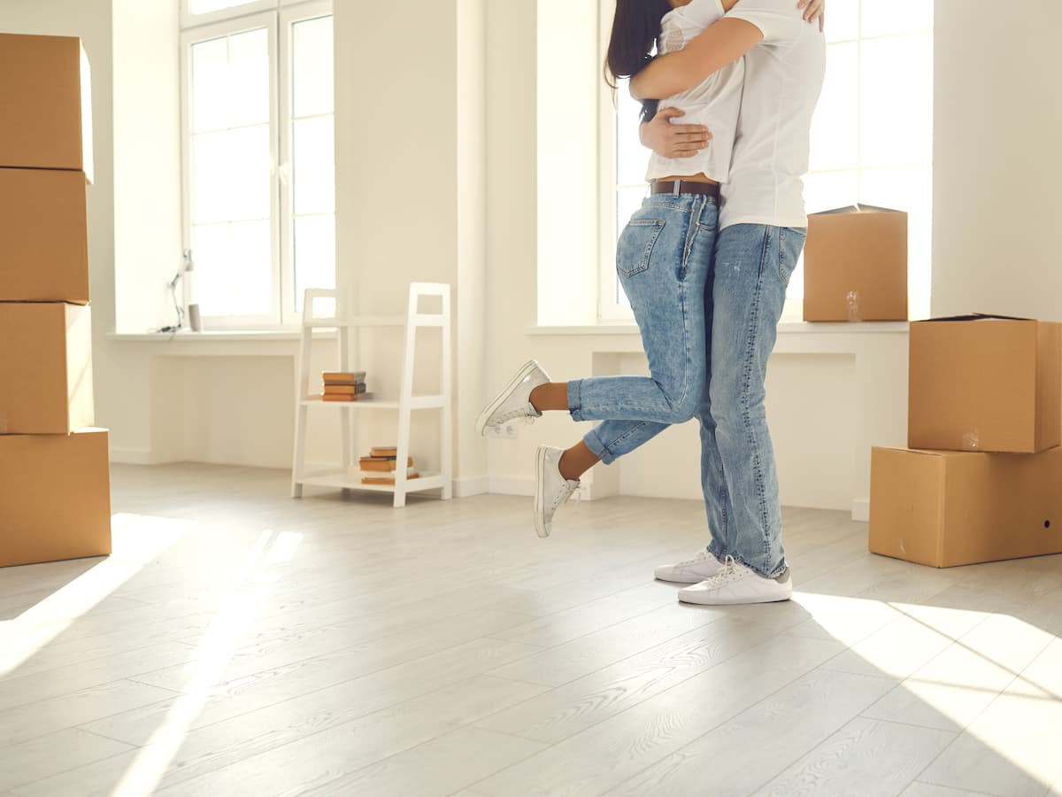 Engaged couple embracing after moving in to their first house