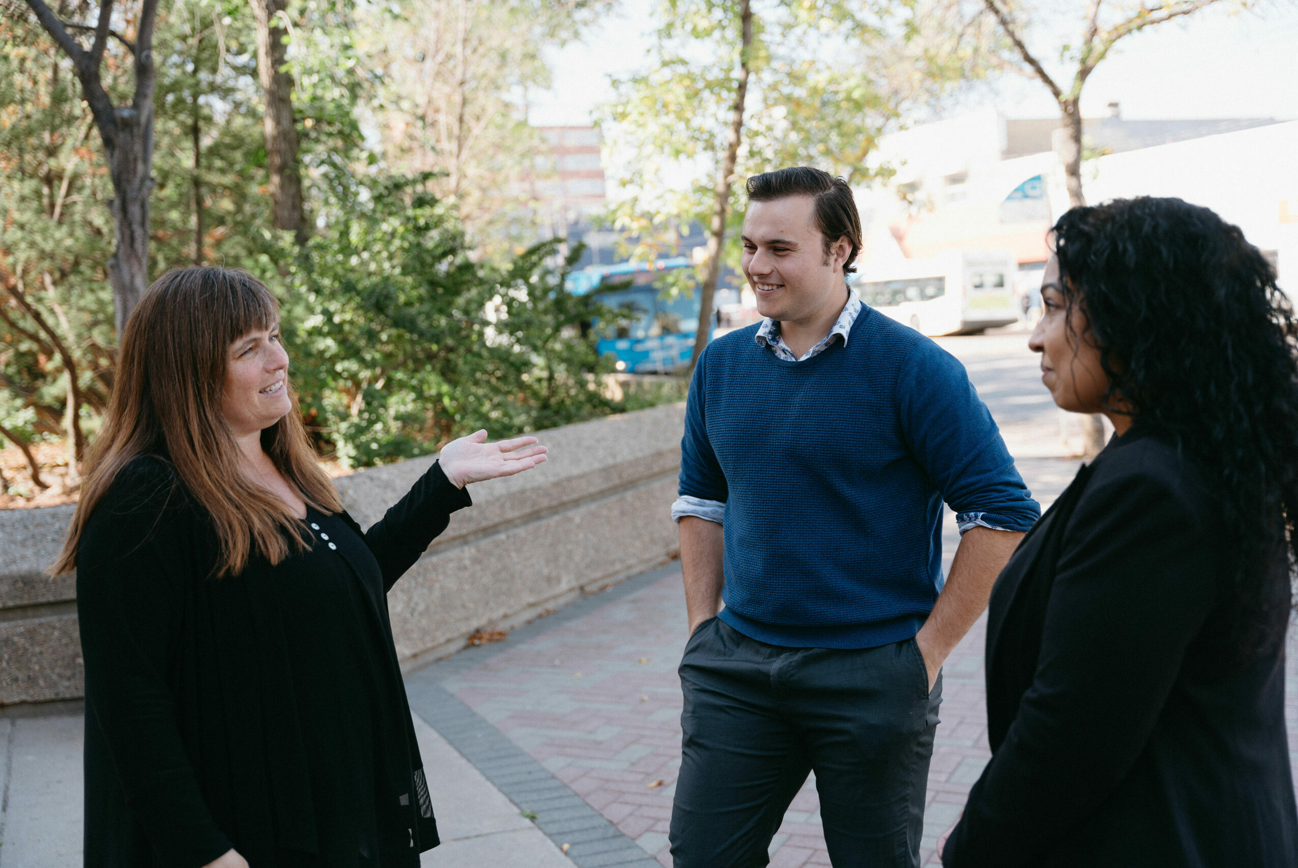 Three people discussing things in a park